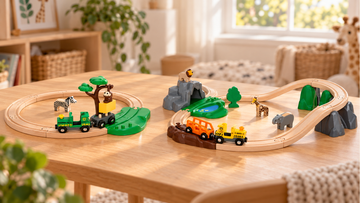 Two separate safari railway scenes on a wooden table: monkey and zebra on the left; lion, elephant and giraffe on the right.